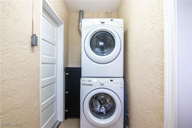 1316 Sunbury Dr, Fort Myers, FL 33901 - washroom featuring stacked washing maching and dryer, tile patterned flooring, a textured wall, and laundry area