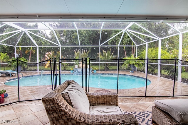 view of pool with glass enclosure and a patio area