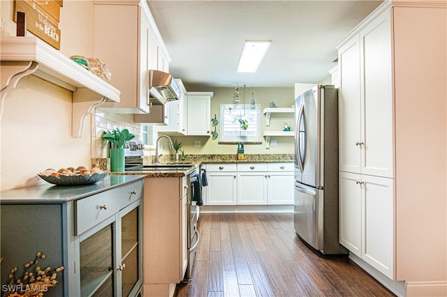 kitchen with appliances with stainless steel finishes, custom range hood, white cabinetry, sink, and dark hardwood / wood-style flooring