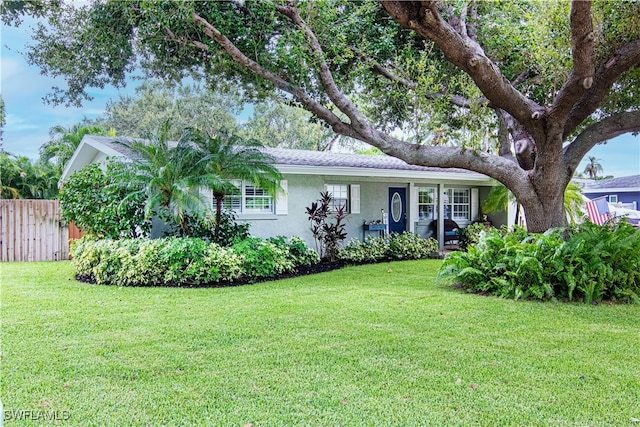 ranch-style home with fence, a front lawn, and stucco siding