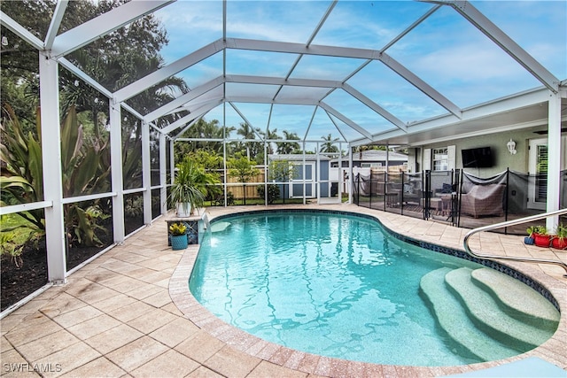 view of pool with glass enclosure, fence, a fenced in pool, and a patio