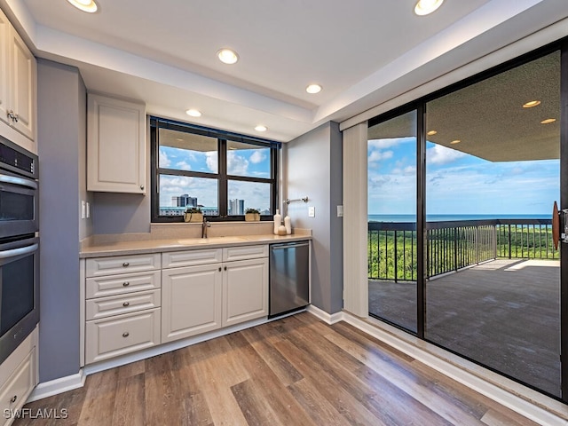 kitchen featuring white cabinets, stainless steel appliances, light hardwood / wood-style floors, and sink