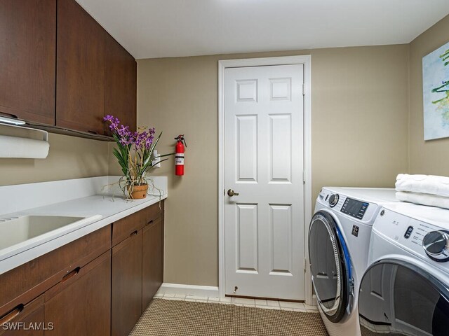 washroom featuring cabinets, light tile patterned flooring, and washing machine and dryer