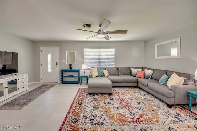 living room with visible vents, ceiling fan, baseboards, and wood finished floors