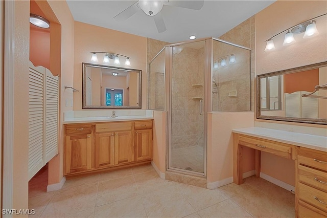 full bath with tile patterned flooring, ceiling fan, vanity, and a shower stall