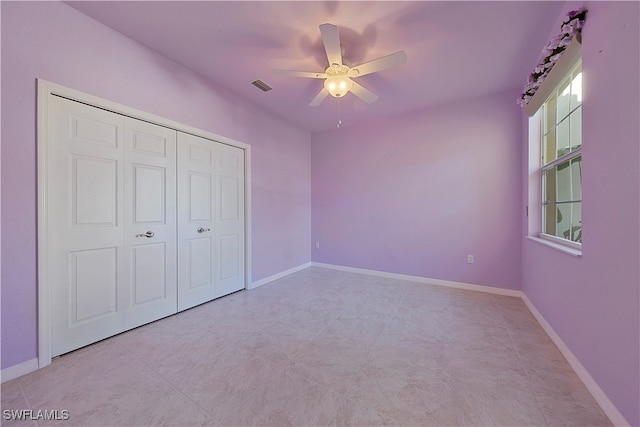 unfurnished bedroom with ceiling fan, light tile patterned floors, and a closet