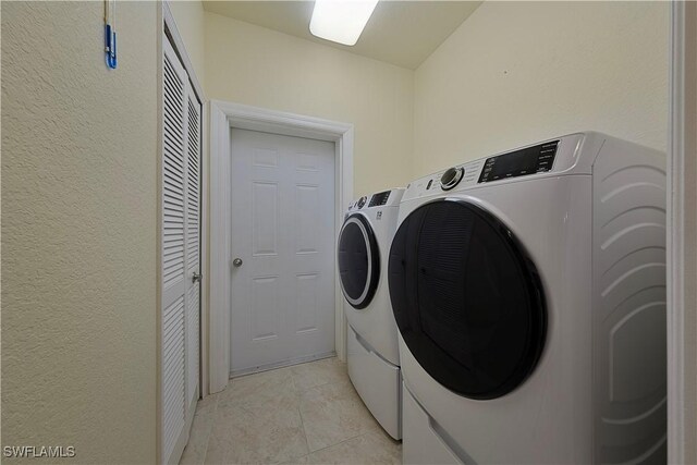 laundry room with light tile patterned flooring and washing machine and clothes dryer