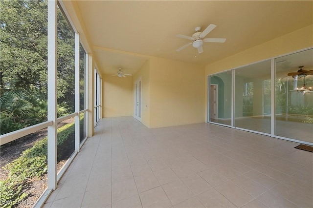 unfurnished sunroom featuring ceiling fan