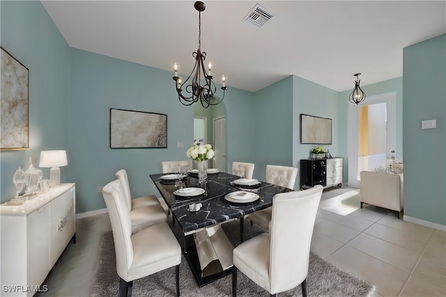 dining room with a notable chandelier and light tile patterned flooring