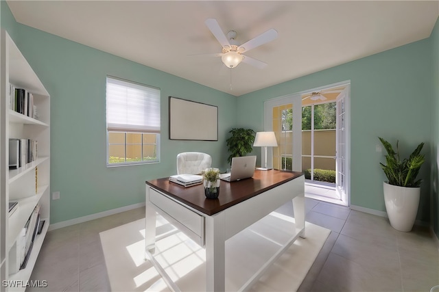 office featuring ceiling fan, light tile patterned flooring, and a healthy amount of sunlight