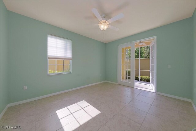 tiled spare room featuring plenty of natural light and ceiling fan