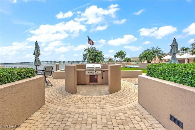 view of patio with area for grilling and a grill