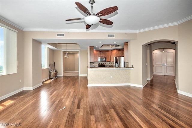 unfurnished living room featuring hardwood / wood-style floors, ornamental molding, and ceiling fan