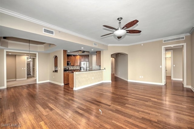 unfurnished living room featuring crown molding, dark wood-type flooring, visible vents, ceiling fan, and arched walkways