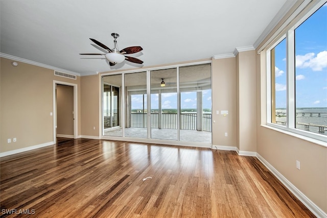 unfurnished room featuring ceiling fan, wood-type flooring, and ornamental molding