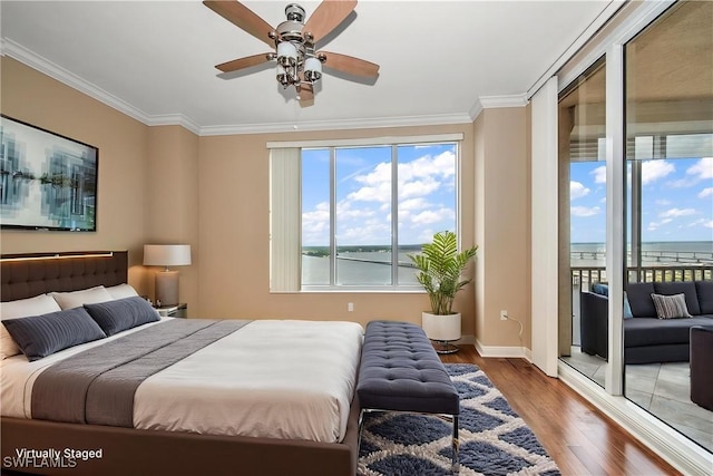 bedroom with a water view, ornamental molding, access to outside, and wood finished floors