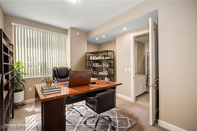 office area featuring baseboards and light colored carpet