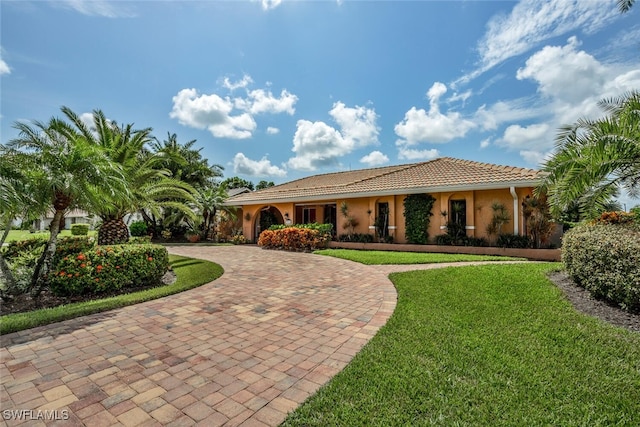 mediterranean / spanish home with a front lawn