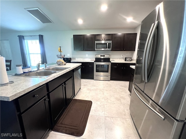 kitchen with sink, appliances with stainless steel finishes, and light tile patterned floors