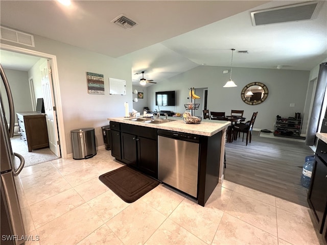 kitchen with light wood-type flooring, stainless steel dishwasher, ceiling fan, pendant lighting, and a center island with sink