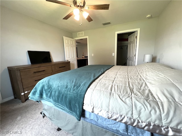 bedroom featuring ceiling fan, a closet, carpet floors, and a walk in closet