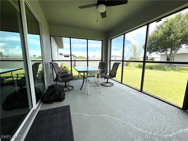 unfurnished sunroom featuring ceiling fan