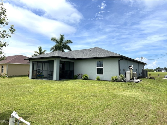 back of house with a lawn and a sunroom