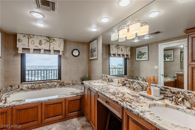 bathroom featuring tile patterned floors, dual vanity, and a tub to relax in