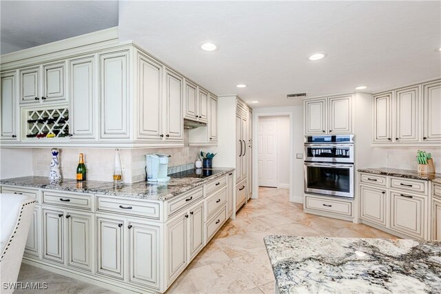 kitchen featuring double oven, light tile patterned floors, decorative backsplash, and light stone counters