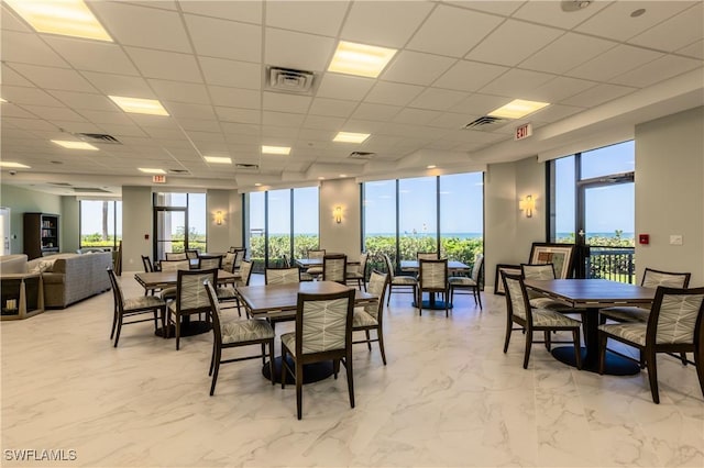 tiled dining room featuring a paneled ceiling