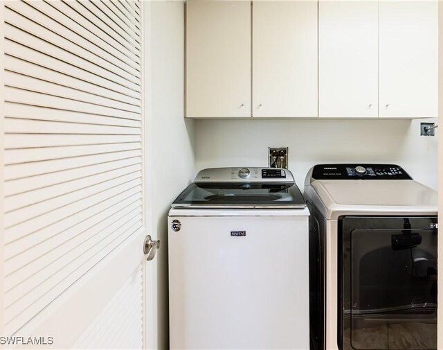 laundry room featuring independent washer and dryer and cabinets