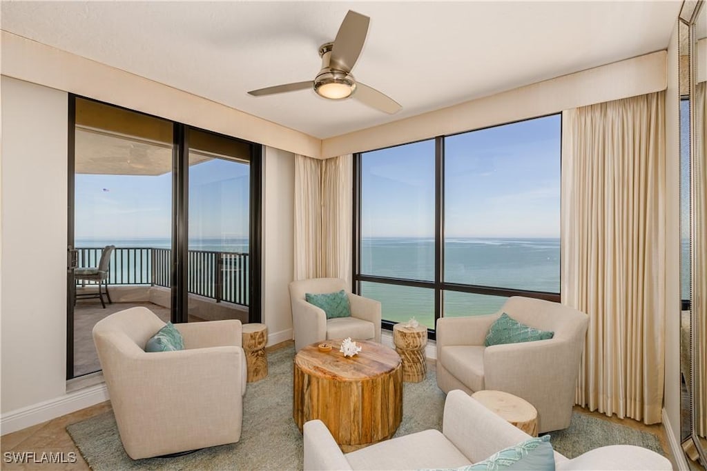 interior space featuring a water view, plenty of natural light, baseboards, and ceiling fan