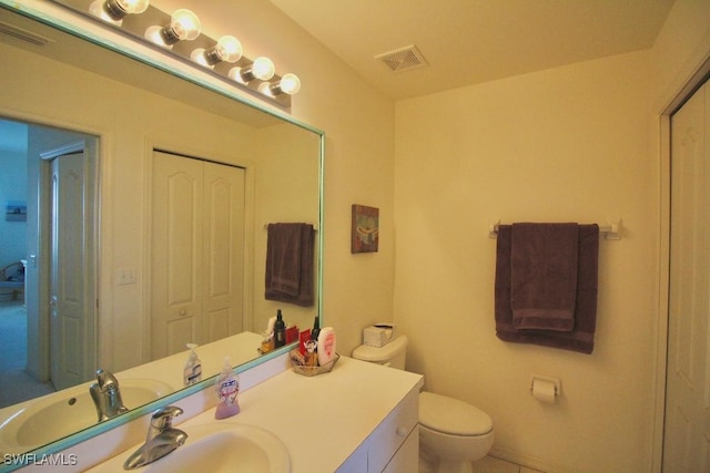 bathroom featuring tile patterned flooring, vanity, and toilet