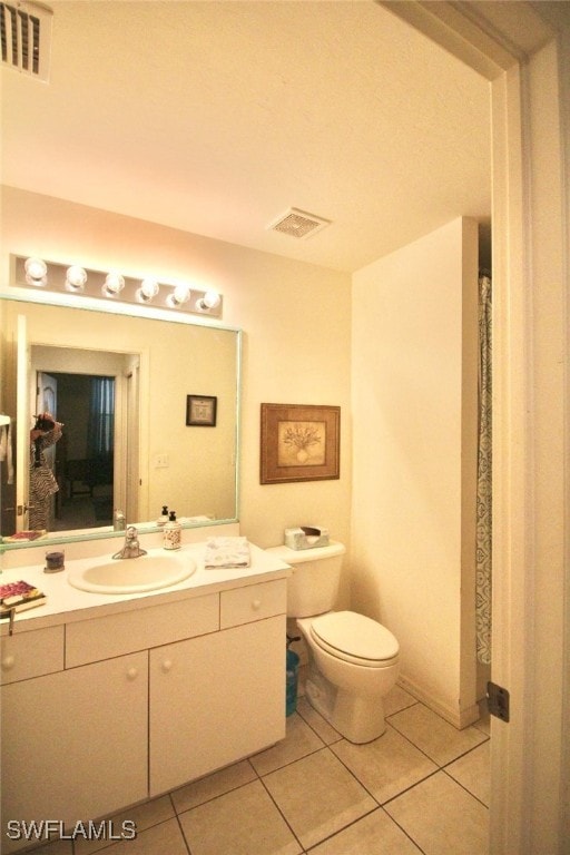 bathroom with tile patterned flooring, vanity, and toilet