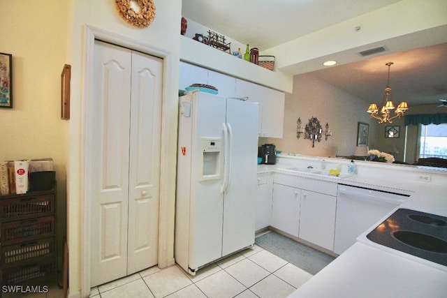 kitchen featuring pendant lighting, white appliances, sink, white cabinetry, and a chandelier