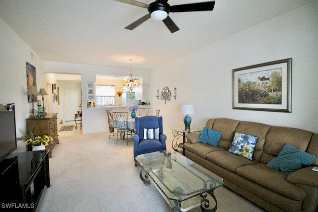 carpeted living room featuring ceiling fan with notable chandelier