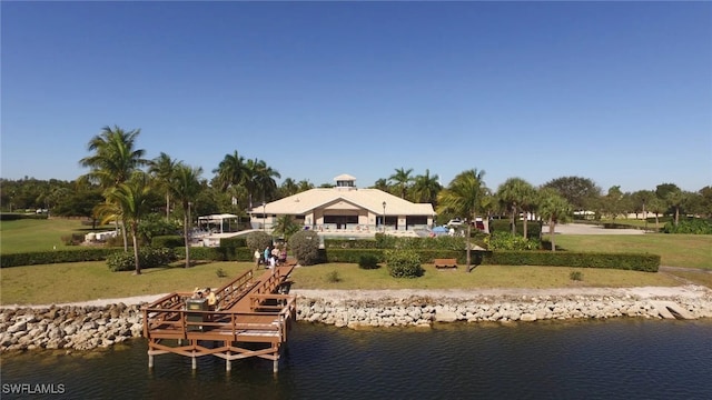 view of dock with a yard and a water view