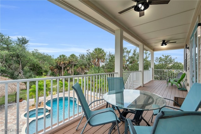 deck featuring ceiling fan and a pool with hot tub