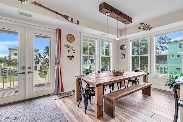 dining space featuring beamed ceiling and french doors