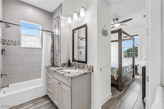 bathroom with shower / bathtub combination with curtain, ceiling fan, vanity, and a healthy amount of sunlight