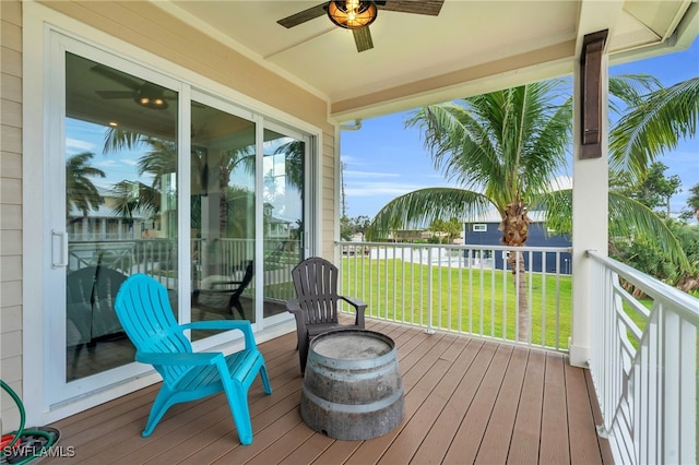 deck featuring ceiling fan and a yard