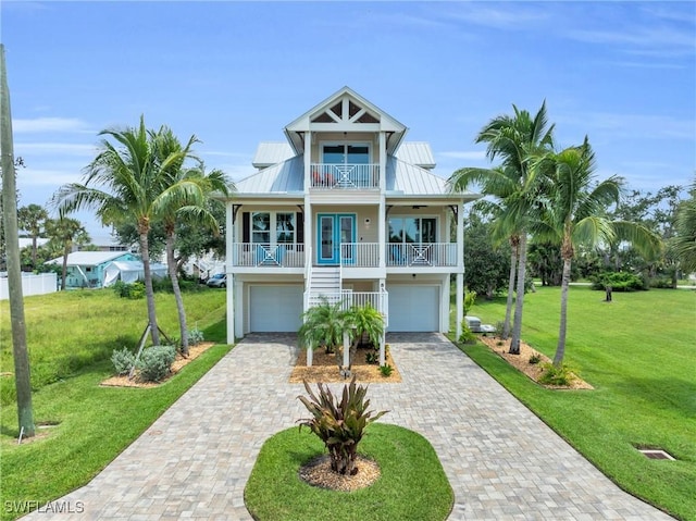 raised beach house with french doors, a garage, a porch, and a front yard