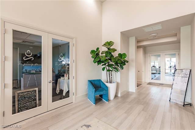 corridor with hardwood / wood-style flooring and french doors