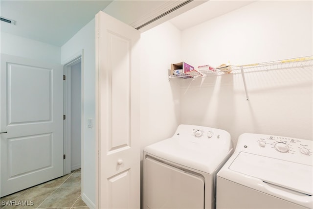 laundry room with washer and dryer and light tile patterned flooring