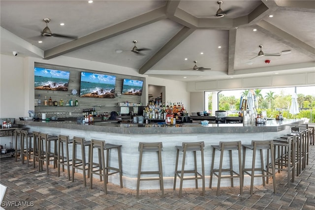 kitchen featuring ceiling fan, lofted ceiling with beams, kitchen peninsula, and dark tile patterned floors