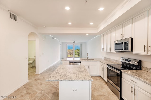 kitchen featuring sink, light stone counters, a kitchen island, stainless steel appliances, and kitchen peninsula