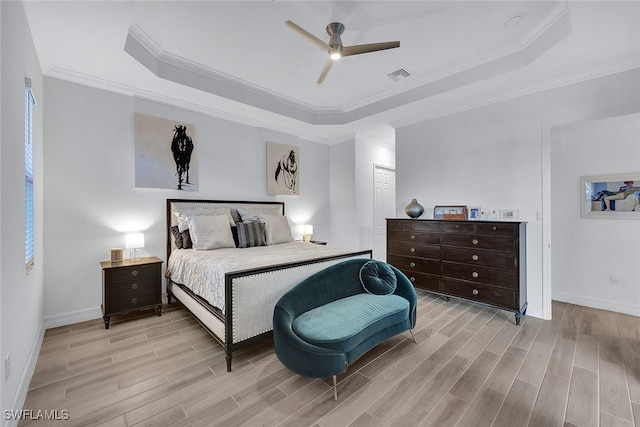 bedroom with ceiling fan, a raised ceiling, and ornamental molding