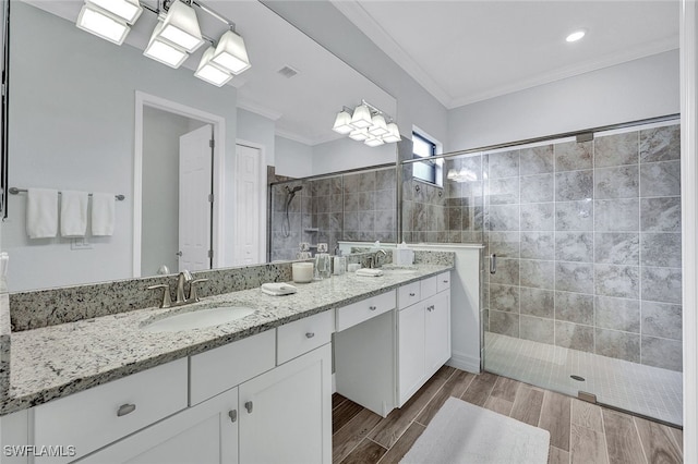 bathroom featuring crown molding, a tile shower, double vanity, and hardwood / wood-style floors