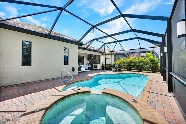 view of swimming pool with a patio, glass enclosure, and an in ground hot tub