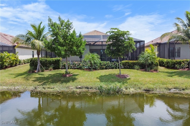 exterior space featuring a lanai, a water view, and a yard